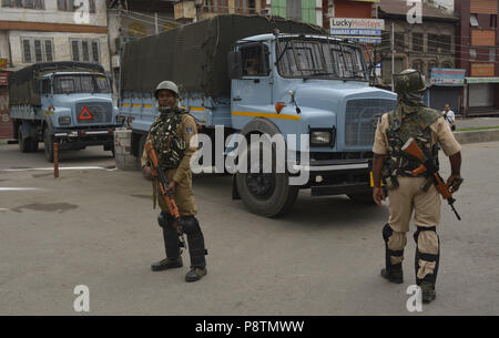 Budgam, Jammu-et-Cachemire, en Inde. Le 13 juillet, 2018. Les troupes paramilitaires indiennes se tient près de l'alerte dans le cimetière des Martyrs à Srinagar, la capitale d'été du Cachemire sous contrôle indien, l'Inde, au cours d'une cérémonie pour marquer l'anniversaire du martyre de Cachemiriens tué par l'armée d'un roi hindou. Les autorités indiennes en Srinagar déployé des milliers de personnel de sécurité dans la principale ville de Srinagar à empêcher la protestation anti-Indiens dans le centre-ville de Srinagar. Chaque année le 13 juillet Cachemire observe le martyre anniversaire de 23 Musulmans qui ont été tués par les forces de Maharaja Hari Singh Banque D'Images