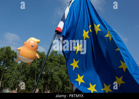 Londres, Royaume-Uni. Le 13 juillet, 2018. Le ballon gonflable appelé Trump Bébé vole au-dessus de l'Union européenne drapeau dans la place du Parlement de Westminster, le siège du Parlement britannique, au cours de la visite du président américain au Royaume-Uni. Trump est un bébé 20m de haut représentant le ballon orange nous Président comme un furieux, le débrayage du smartphone - et étant donné la permission spéciale d'apparaître au dessus de la capitale par le maire de Londres Sadiq Khan à cause de sa protestation au lieu de nature artistique. Il est l'invention de Graphic Designer Matt Bonner. Credit : RichardBaker/Alamy Live News Banque D'Images