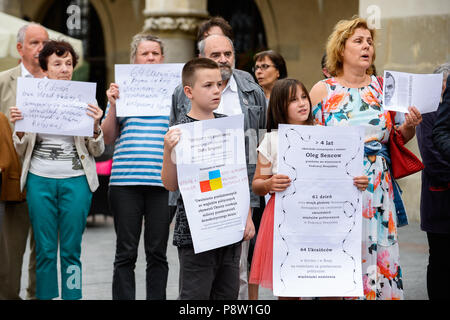 Cracovie, Pologne. Le 13 juillet, 2018. Vu les gens tenant des affiches pendant la manifestation.protestation exigeant la libération du cinéaste et écrivain ukrainien, Oleg Sentsov à la place principale de Cracovie qui a été condamné à 20 ans pour complot en vue de commettre des actes de terreur. Credit : Omar Marques/SOPA Images/ZUMA/Alamy Fil Live News Banque D'Images