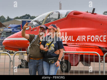 Fairford, UK, 13 juillet 2018. Un couple prendre un en selfies face de l'un des jets de la RAF's Red Arrows display team au Royal International Air Tattoo à Fairford, en Angleterre (Photo prise le 13 juillet 2018)Crédit : Ceri/Alamy Breeze Live News Banque D'Images