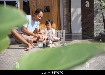 Portrait de père et fille chaussures Nettoyage ensemble. La parentalité positive concept Banque D'Images