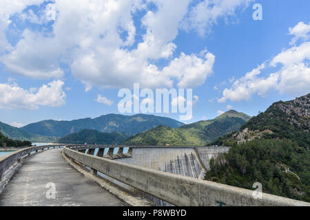 Chemin de ronde au-dessus d'un barrage à partir de son point de départ à la fin au printemps sous quelques nuages et entouré de montagnes et forêts à Amer, Espagne Banque D'Images