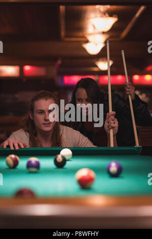 Couple playing billards dans le club Banque D'Images