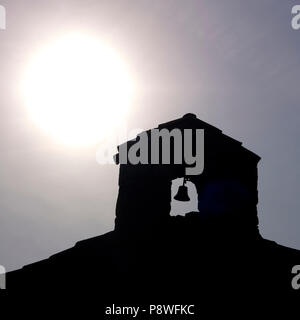 Close up de la cloche et le clocher d'une petite chapelle dans le rétroéclairage, Auvergne, France Banque D'Images