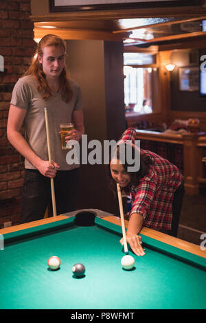 Couple playing billards dans le club Banque D'Images