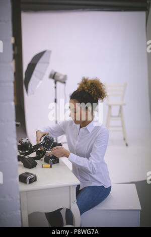 Femme photographe de la dépose du rabatteur à partir d'un appareil photo numérique Banque D'Images
