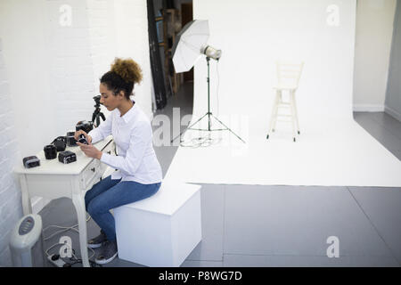 Femme photographe de la dépose du rabatteur à partir d'un appareil photo numérique Banque D'Images