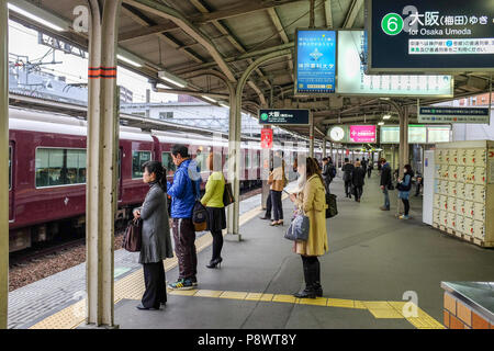 Les navetteurs sur une plate-forme à la gare Juso le long de la ligne de chemin de fer Hankyu Kobe. C'est l'une des trois lignes de trains de banlieue dans la région de Kobe Osaka. Banque D'Images