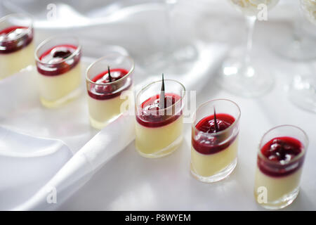 Délicieux dessert de fromage à la crème avec garniture cerise servi dans un pot Banque D'Images