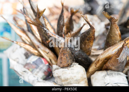 Petit poisson emballé dans un journal à vendre sur la stalle du marché, Ghana Banque D'Images