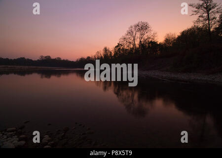 Réflexion sur le coucher du soleil de feu rouge river, en Italie. Banque D'Images