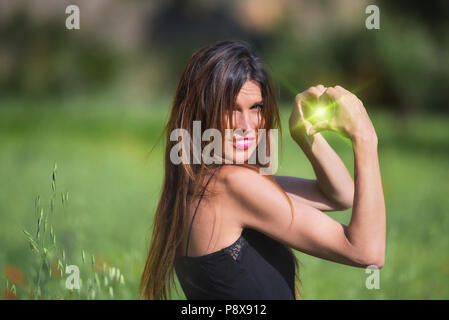 Femme souriante. Symbole coeur vert en forme avec l'intérieur de la torche. L'amour, la nature concept. L'écologie et la durabilité. Banque D'Images