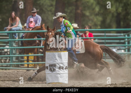 Course de barils dames et excitng les chevaux en mouvement rapide. Virages serrés, pleine vitesse, belles cowgirls en compétition. Cranbrook Pro Rodeo Banque D'Images