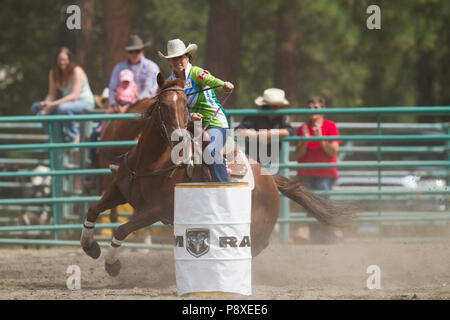 Course de barils dames et excitng les chevaux en mouvement rapide. Virages serrés, pleine vitesse, belles cowgirls en compétition. Cranbrook Pro Rodeo Banque D'Images