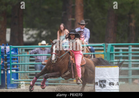 Course de barils dames et excitng les chevaux en mouvement rapide. Virages serrés, pleine vitesse, belles cowgirls en compétition. Cranbrook Pro Rodeo Banque D'Images