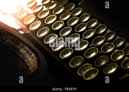 Détail de clavier de machine à écrire avec effet rétro-éclairage aux teintes chaleureuses. Tonalité faible ambiance. Banque D'Images