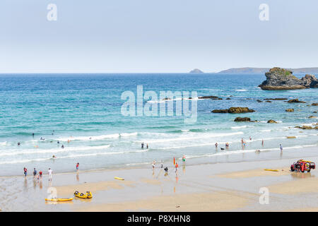 Les vacanciers sur la plage de sable de Trevaunance Cove, St Agnes, Cornwall, Angleterre, où les vagues et surf de l'Atlantique a frappé la côte. Banque D'Images