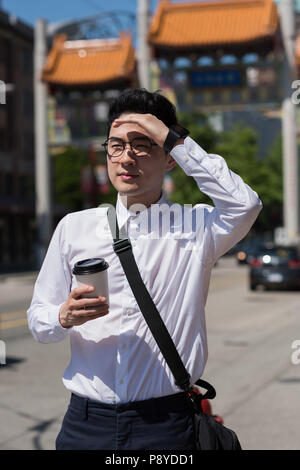 Protection de l'homme ses yeux tout en marchant dans la rue Banque D'Images