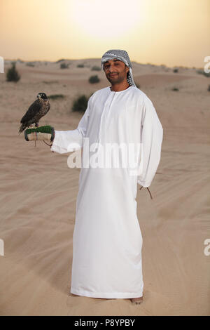 L'homme arabe badawi habillé en robe de style arabe avec des Falcon en Dubai Desert Banque D'Images