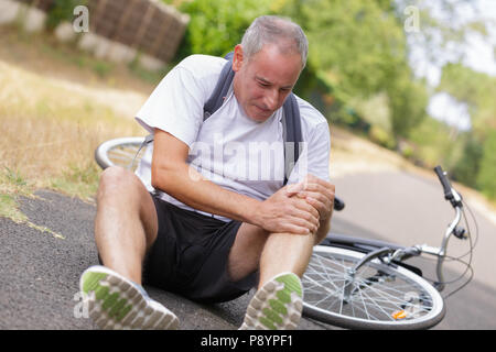 Le cycliste est tombé de vélo à l'articulation du genou blessé Banque D'Images