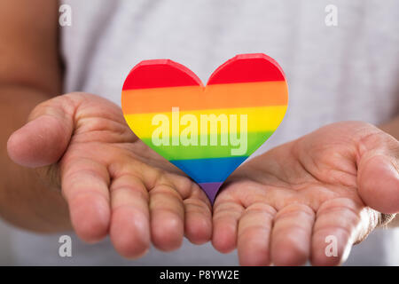 Close-up of a man's hand holding Centre LGBT arc-en-ciel Banque D'Images