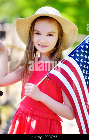 Adorable petite fille holding american flag sur belle journée d'été. Concept de la Journée de l'indépendance. Banque D'Images