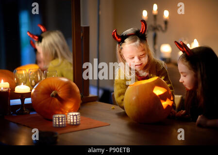 Deux jolies jeunes sœurs dans Halloween costumes sculpture d'un ensemble de citrouille à l'Halloween Banque D'Images