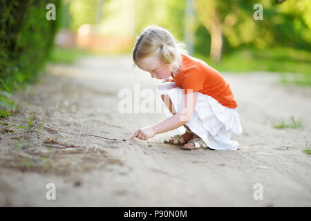 Adorable petite fille attraper peu babyfrogs sur belle journée d'été en forêt Banque D'Images