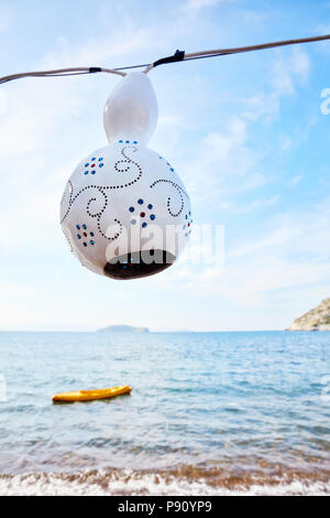 Fait main blanc décoratif calabash gourd pendaison lampe devant un fond de ciel et mer Banque D'Images