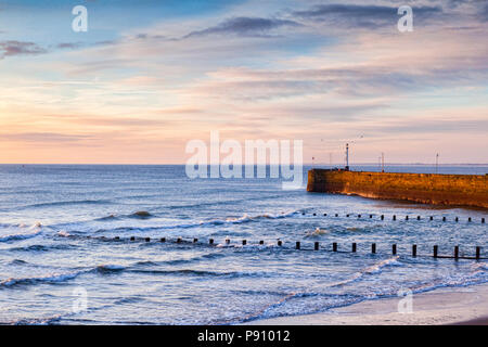 Plage de Bridlington et mur du port, East Riding of Yorkshire, Angleterre, Royaume-Uni, l'hiver le lever du soleil. Banque D'Images