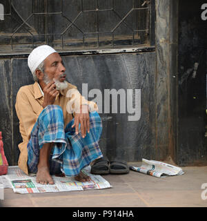 Homme assis en indien local street prises à partir d'un tricycle en mouvement à travers les rues animées de Delhi Inde Banque D'Images