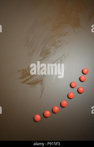 Mat beaux bonbons, frissonnant rouge bonbon sur un fond mat brun. Banque D'Images