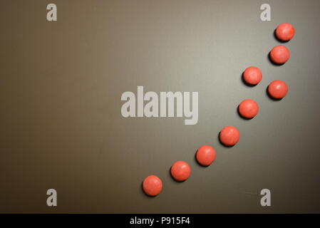 Mat beaux bonbons, frissonnant rouge bonbon sur un fond mat brun. Banque D'Images