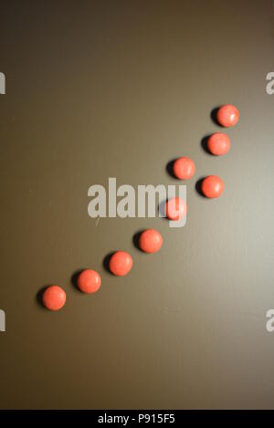 Mat beaux bonbons, frissonnant rouge bonbon sur un fond mat brun. Banque D'Images