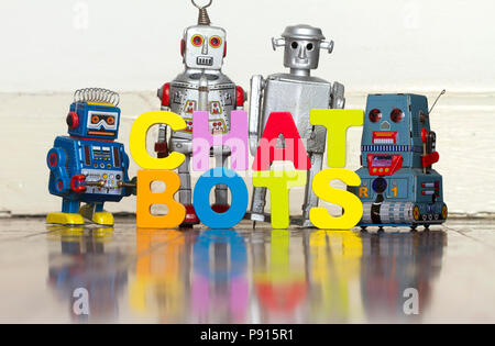 Le mot CHAT BOTS avec retro 4 robots sur un sol en bois avec réflexion Banque D'Images