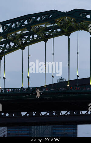 Les membres du Cirque Bijou effectuer un acte de fil à Wearmouth Bridge à Sunderland, en Angleterre. L'exploit est partie de divertissement pendant Sunderland accueille la première étape de la course des grands voiliers 2018. Banque D'Images