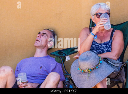 Deux festivaliers se détendre, dormir, homme femme à côté de lui en sirotant un verre, à une latitude Festival, Henham Park, Suffolk, Angleterre, 14 juillet, 2018 Banque D'Images