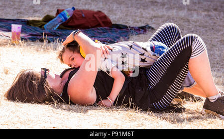 La mère et le fils de câlins sur l'herbe, à la latitude Festival, Henham Park, Suffolk, Angleterre, 14 juillet 2018 Banque D'Images