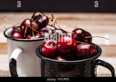 Les cerises mûres fraîches. Les cerises dans la tasse sur la table en bois laqué Banque D'Images