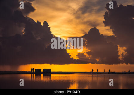 Fort Myers Beach pendant un coucher de soleil. Le ciel se reflète sur une grande flaque qui accumalates sur la plage lorsqu'il pleut. Banque D'Images