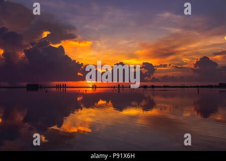 Fort Myers Beach pendant un coucher de soleil. Le ciel se reflète sur une grande flaque qui accumalates sur la plage lorsqu'il pleut. Banque D'Images