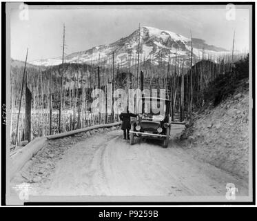 Une automobile électrique de Detroit s'est arrêté sur la route par les terres brûlées, avec montagne couverte de neige en arrière-plan, Washington Banque D'Images