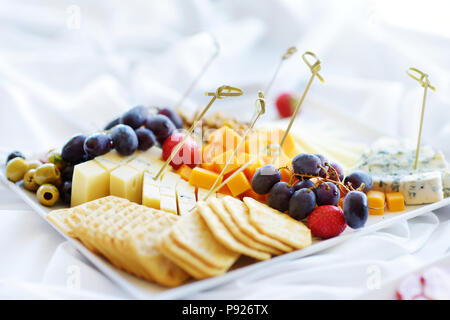 Différents types de vin en-cas : fromages, baguettes, biscuits, fruits et olives de table blanc Banque D'Images