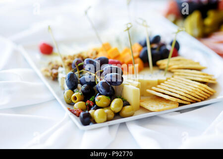 Différents types de vin en-cas : fromages, baguettes, biscuits, fruits et olives de table blanc Banque D'Images