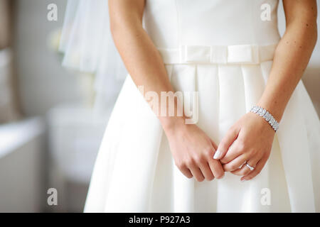 Les mains sur la mariée belle robe de mariée blanche. Mariée de porter un bracelet brillant. Banque D'Images