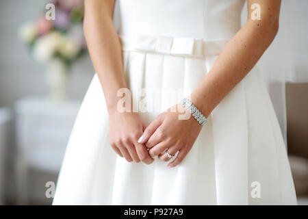 Les mains sur la mariée belle robe de mariée blanche. Mariée de porter un bracelet brillant. Banque D'Images