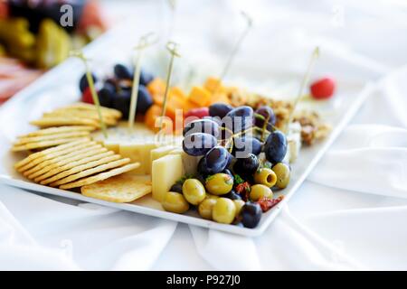 Différents types de vin en-cas : fromages, baguettes, biscuits, fruits et olives de table blanc Banque D'Images