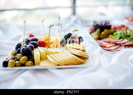 Différents types de vin en-cas : fromages, baguettes, biscuits, fruits et olives de table blanc Banque D'Images