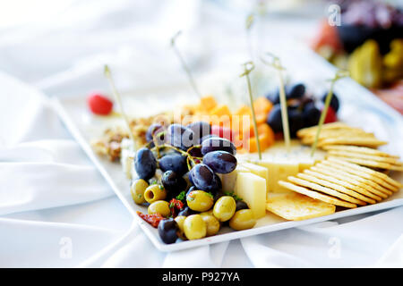 Différents types de vin en-cas : fromages, baguettes, biscuits, fruits et olives de table blanc Banque D'Images