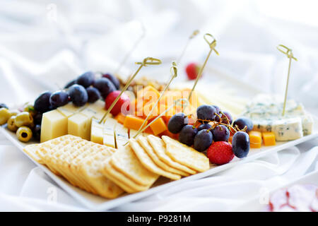 Différents types de vin en-cas : fromages, baguettes, biscuits, fruits et olives de table blanc Banque D'Images